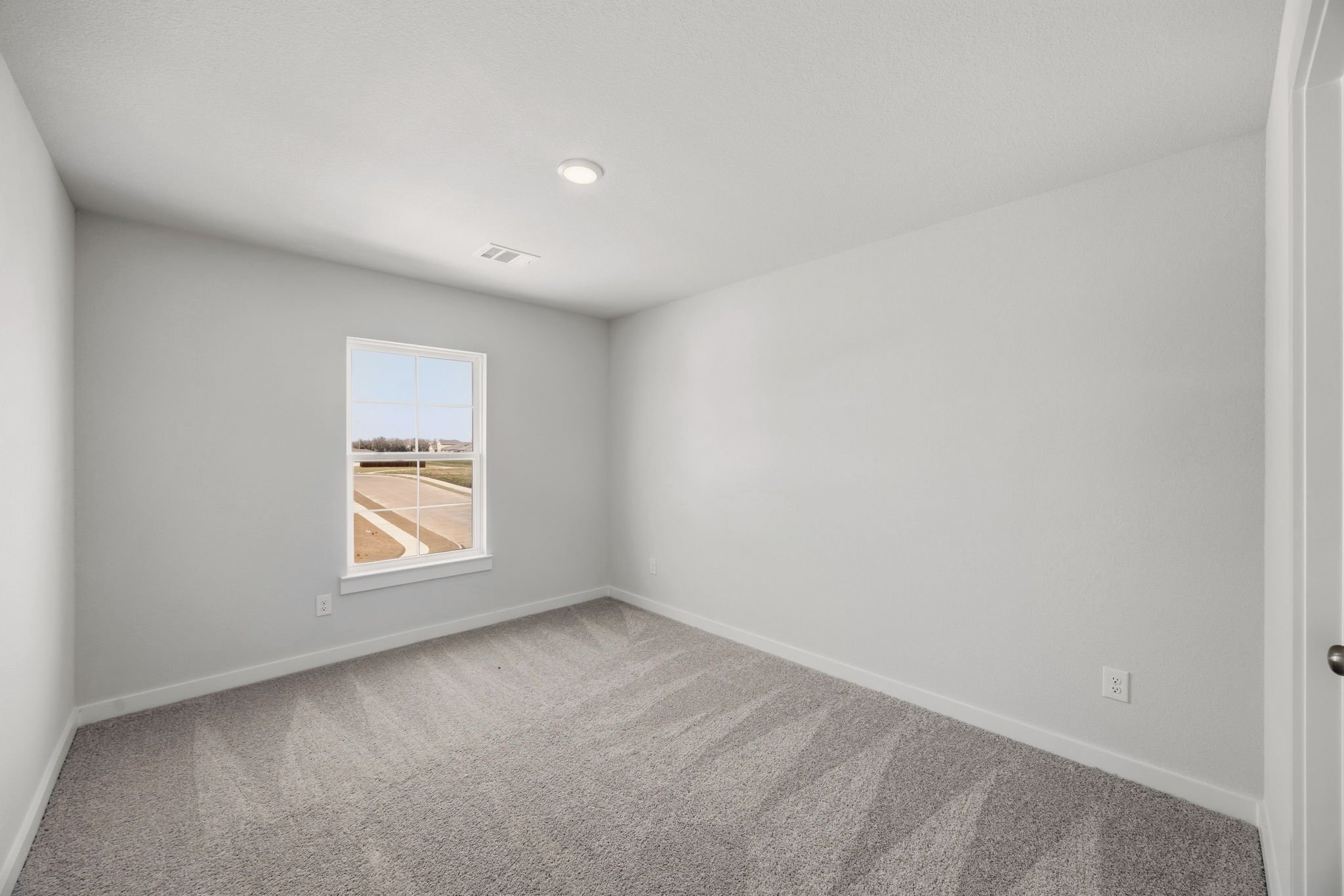 A room with a window and carpet.