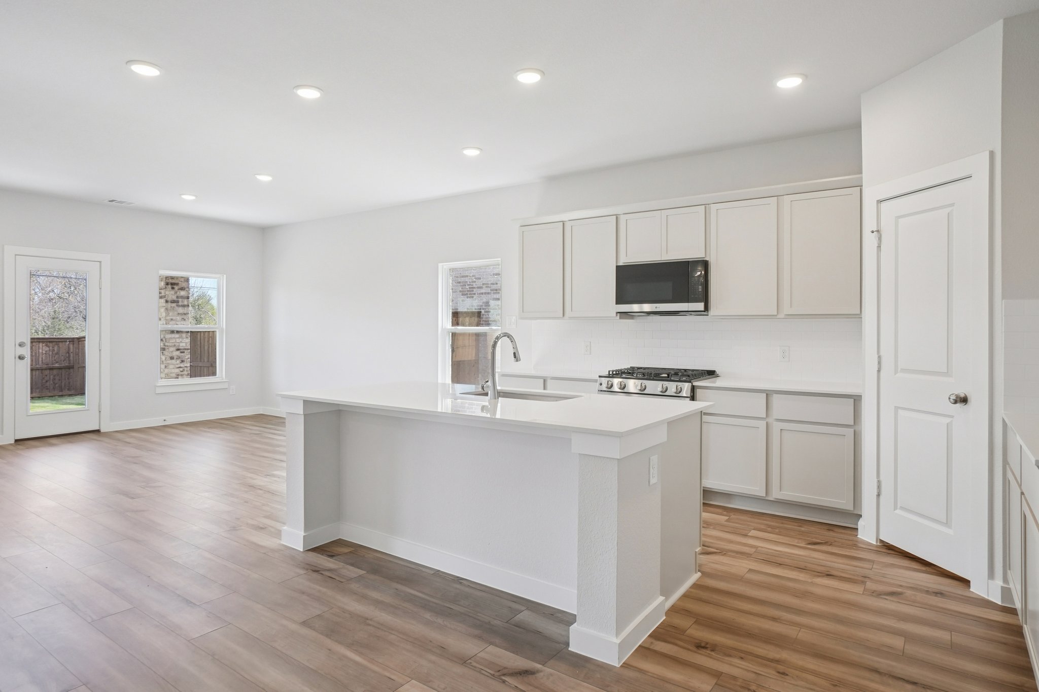 A kitchen with white cabinets.