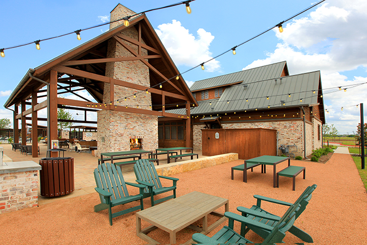 A building with tables and chairs outside.