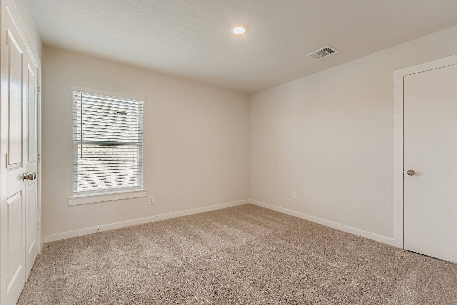 A room with white walls and a carpeted floor.
