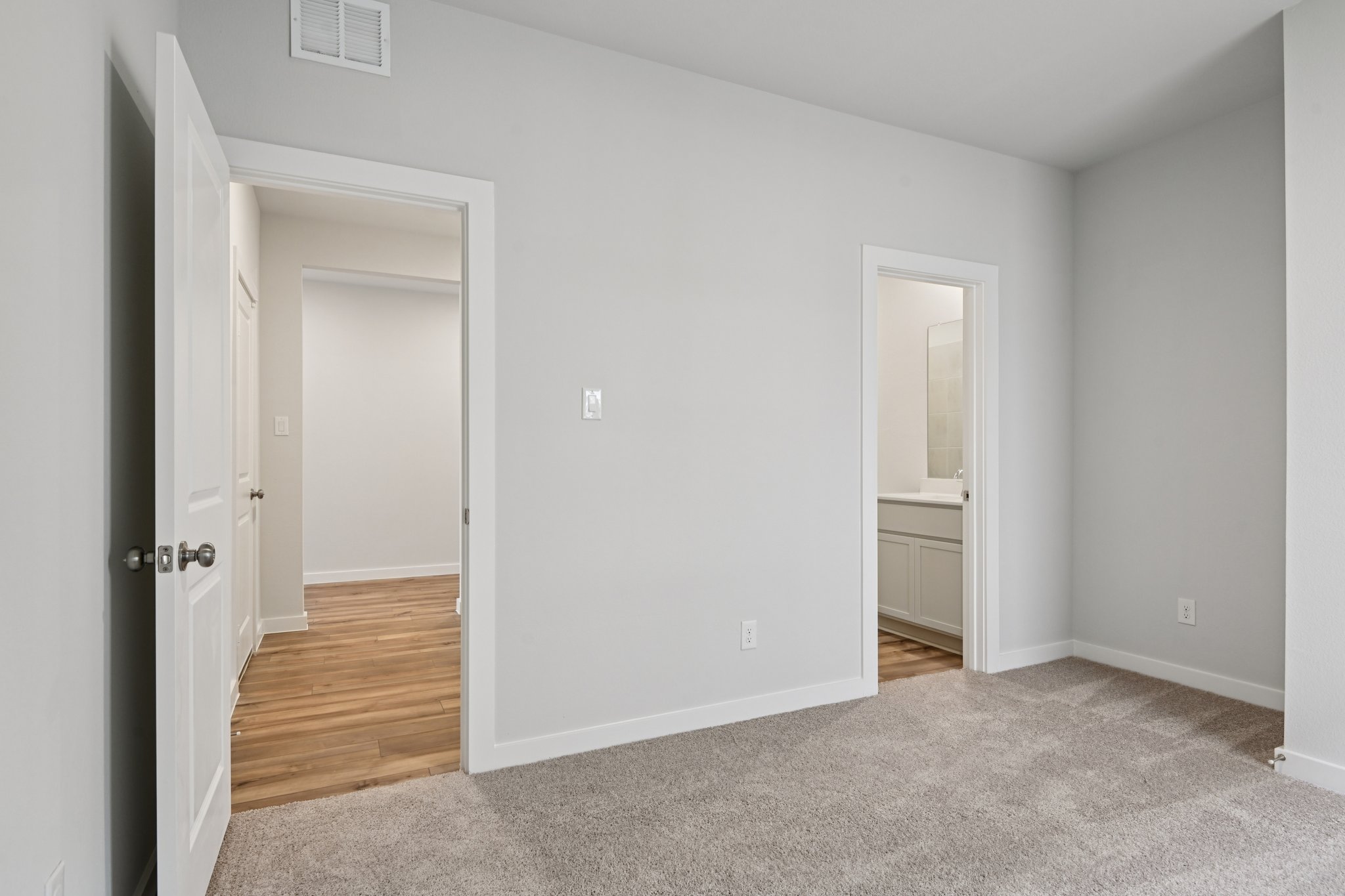 A room with a door and a mirror.