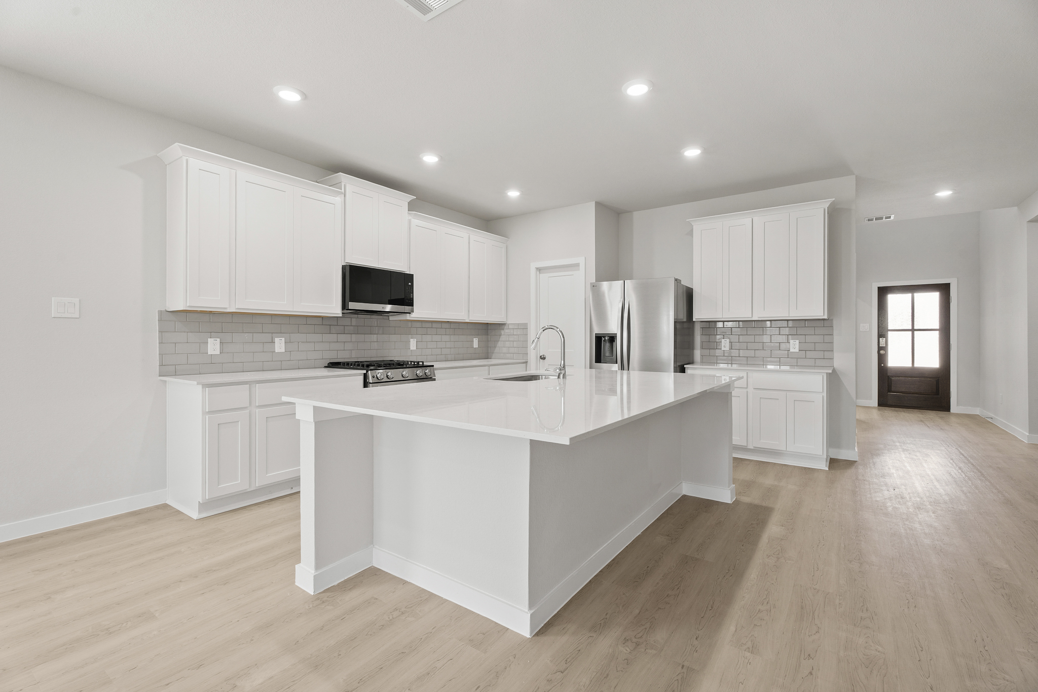 A kitchen with white cabinets.