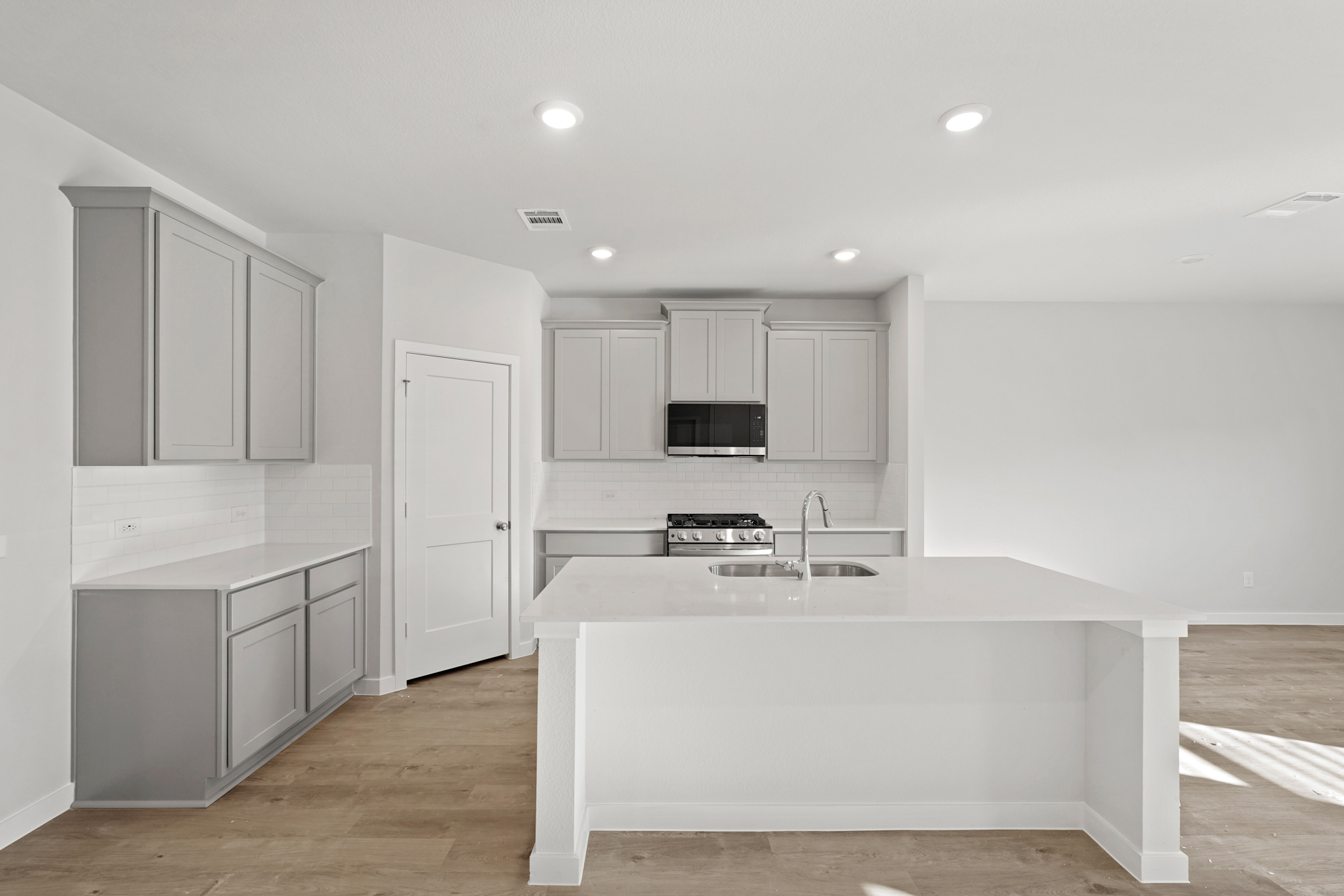 A kitchen with white cabinets.