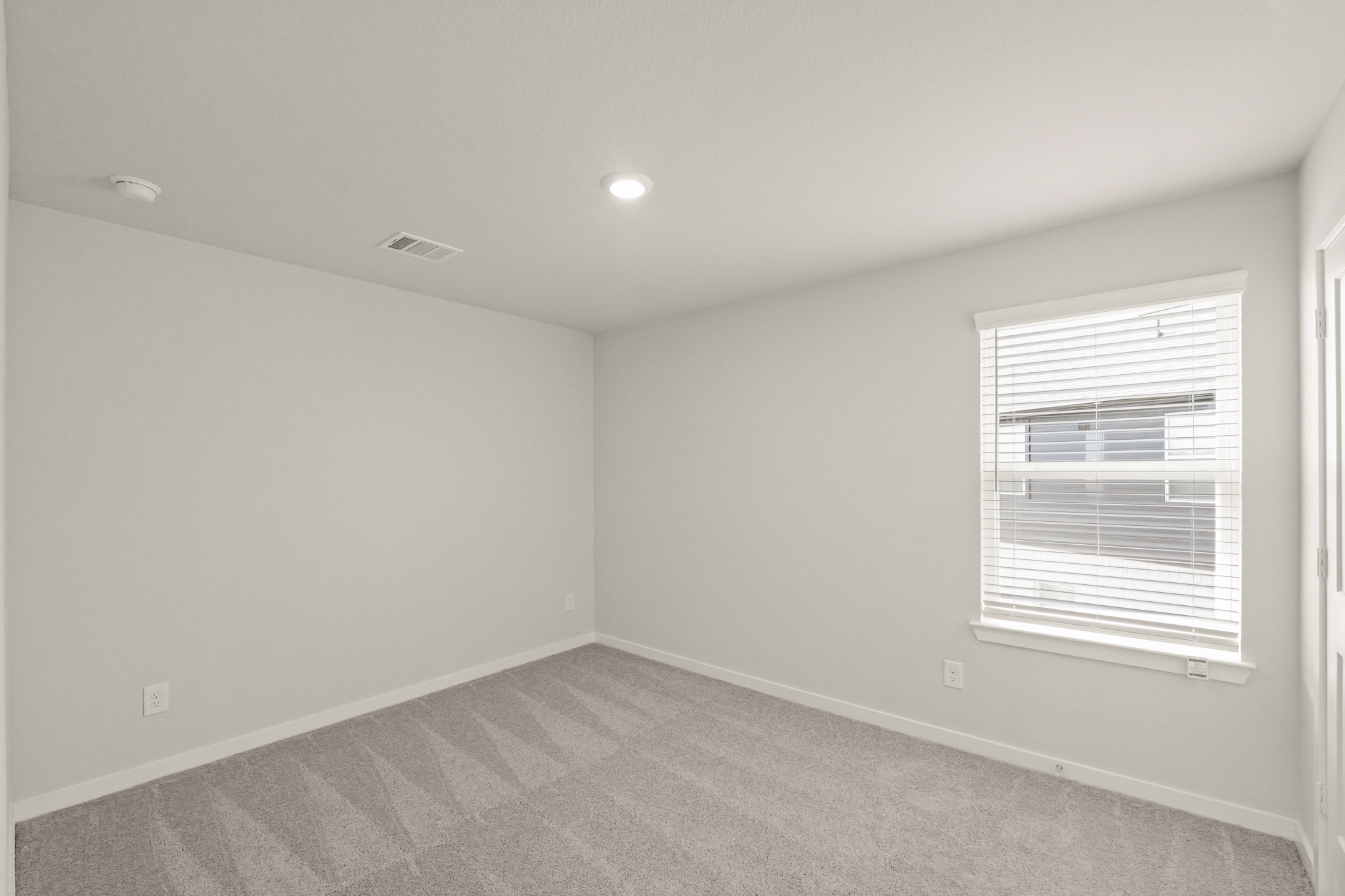 A room with a window and a carpet.