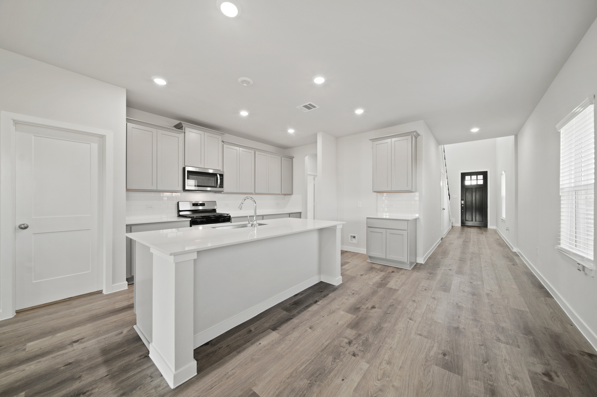 A kitchen with white cabinets.
