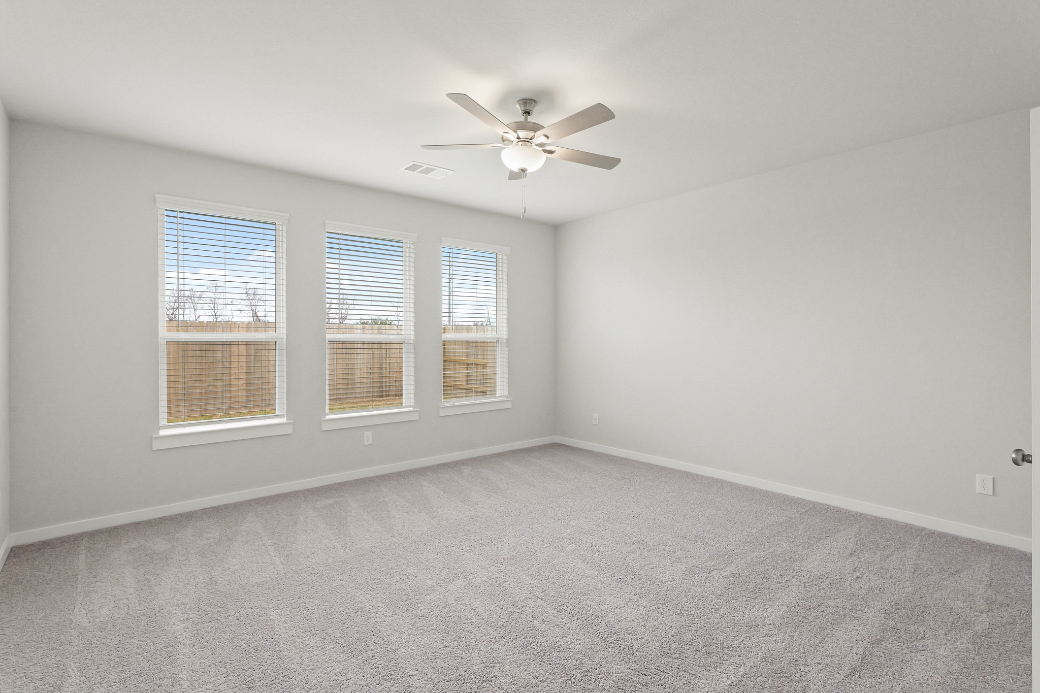A room with a ceiling fan and a window.
