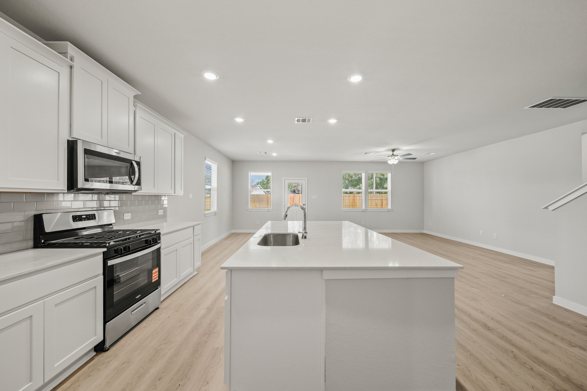 A kitchen with white cabinets.