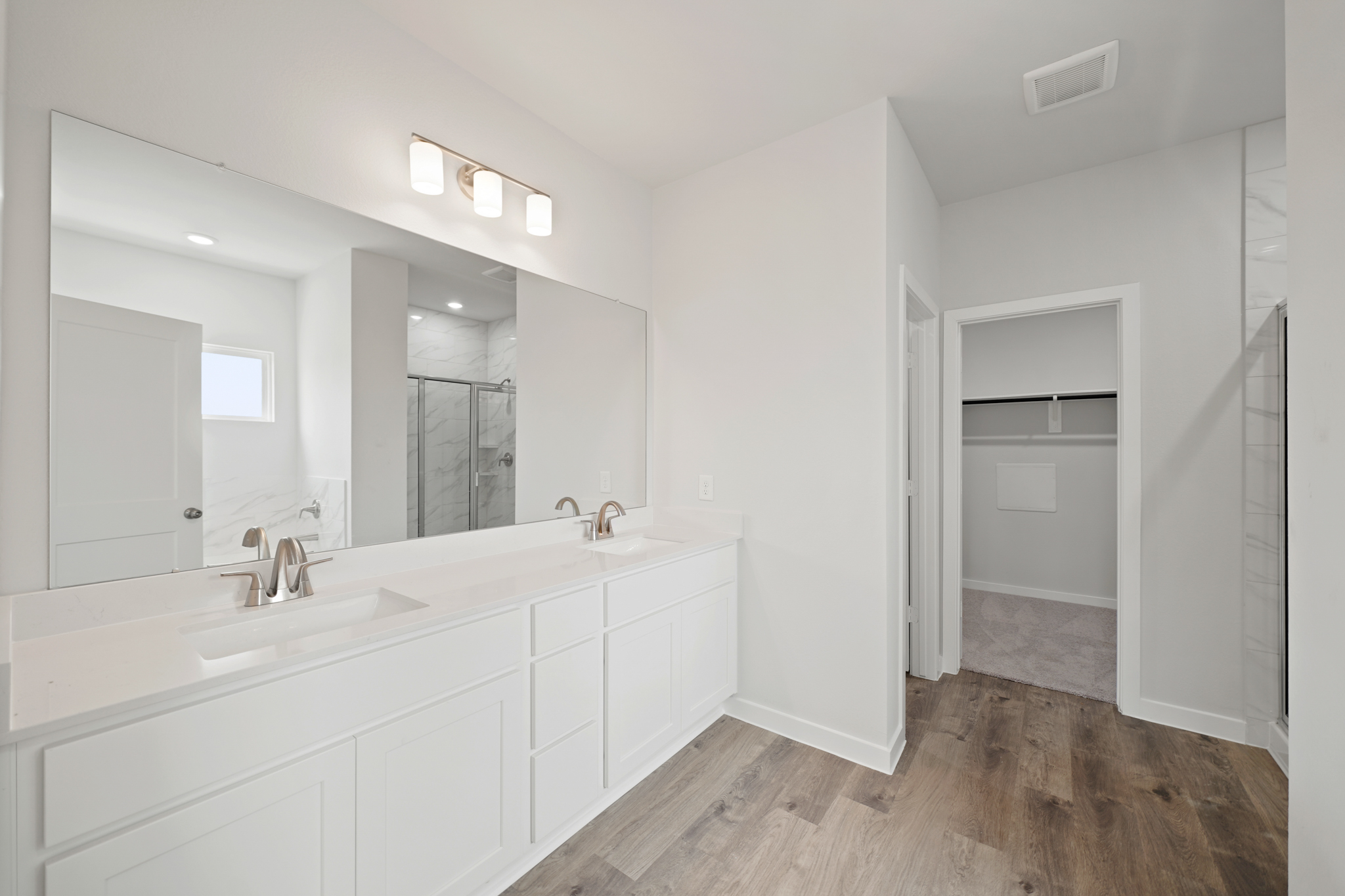 A bathroom with white cabinets.