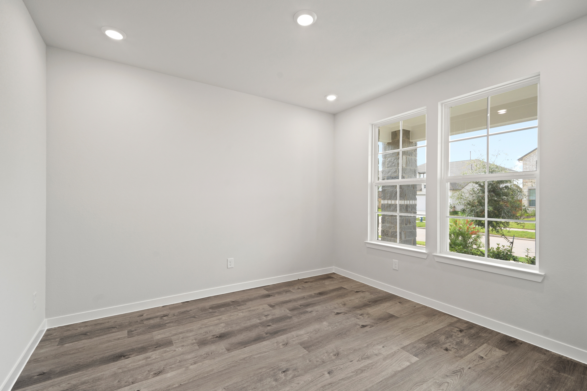 A room with windows and a wood floor.