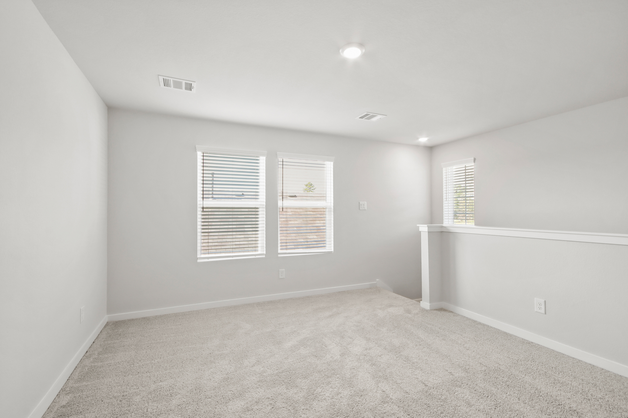 A room with a carpet and a window.