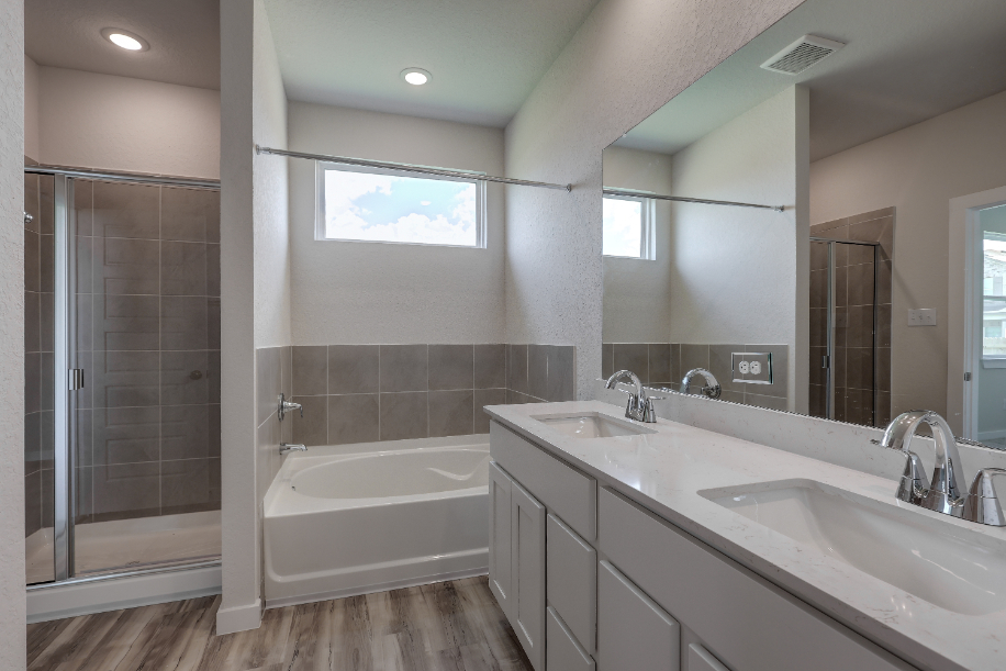 A bathroom with a tub sink and mirror.