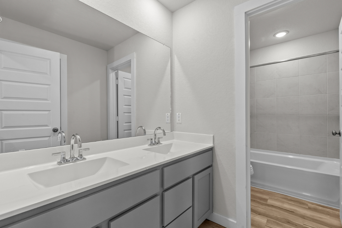 A bathroom with a sink and a mirror.