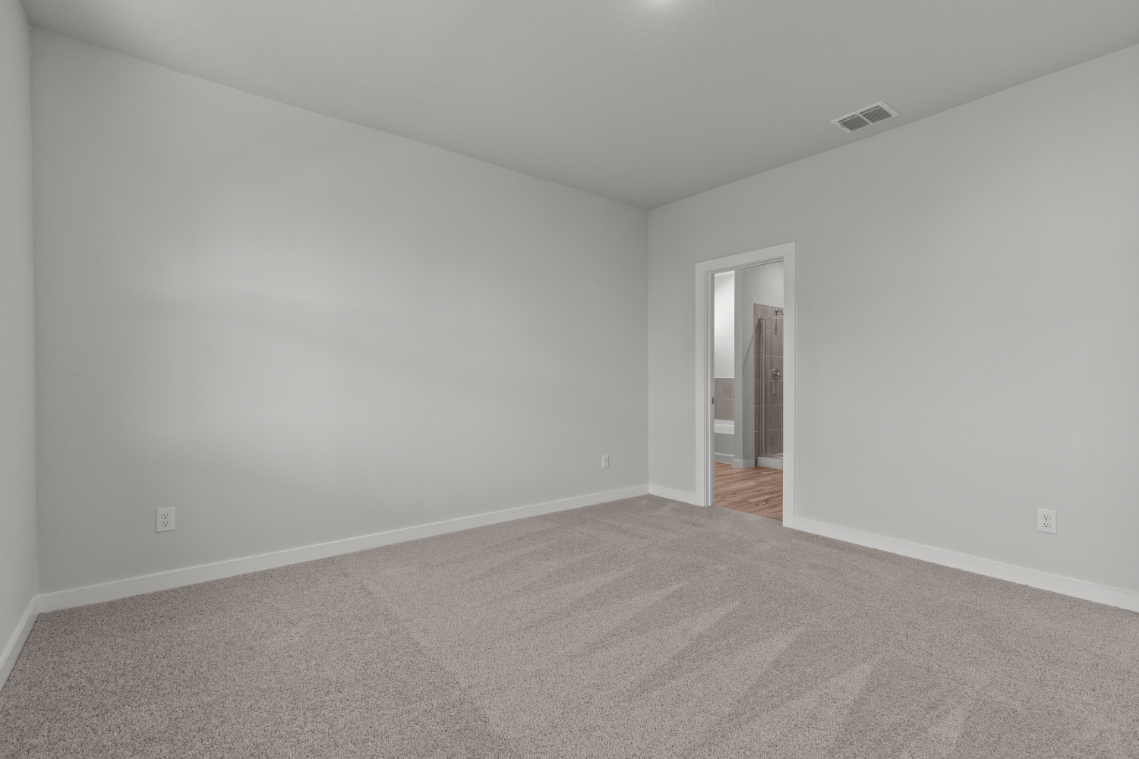 A room with a carpet and a door.