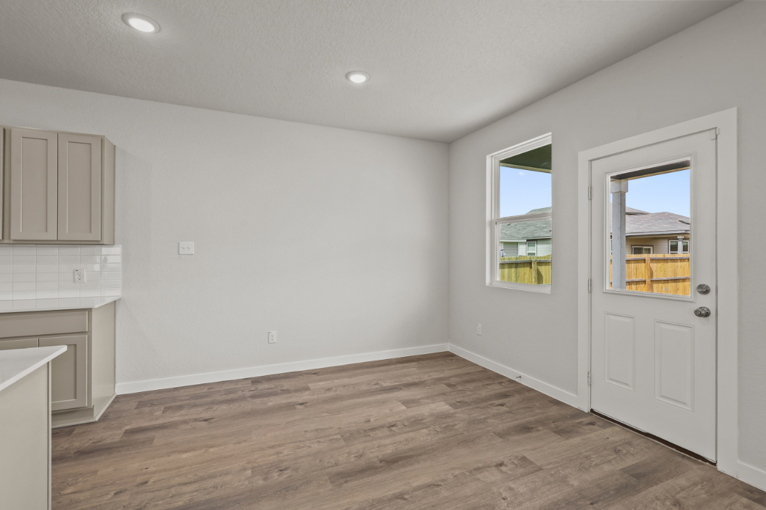 A room with white walls and a wood floor.