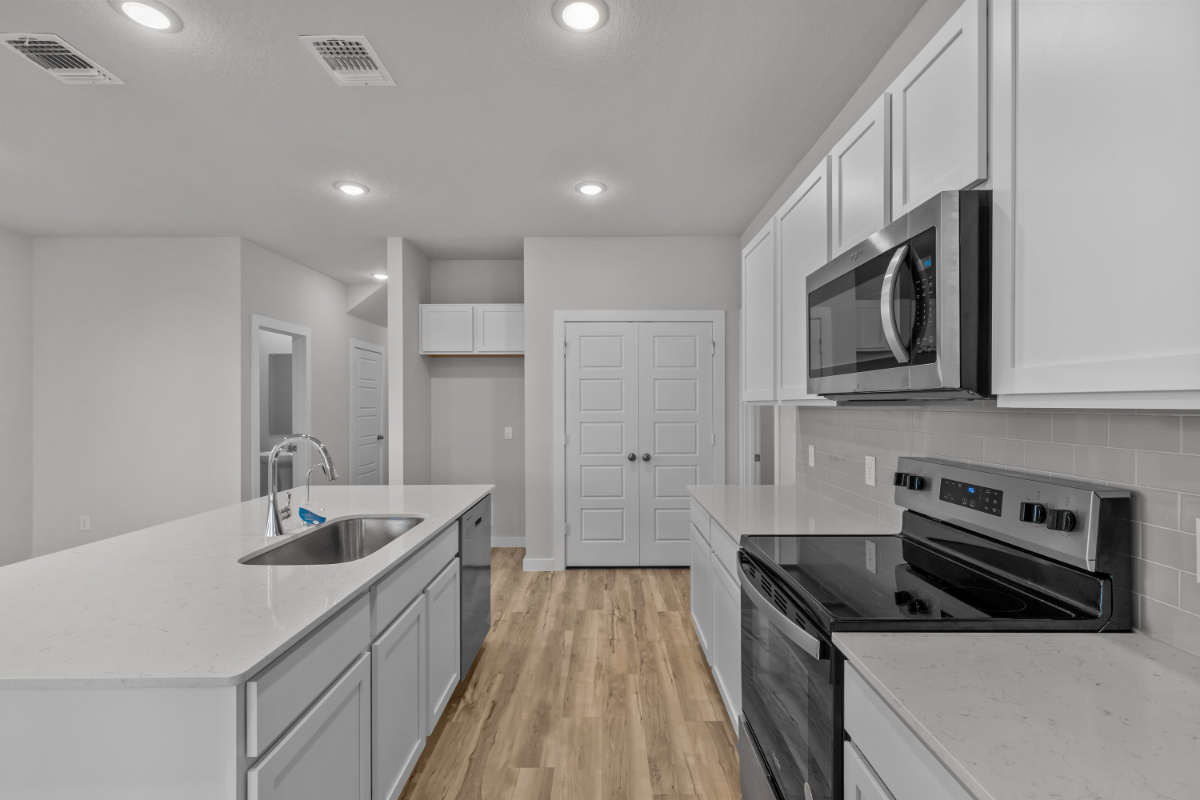 A kitchen with white cabinets.