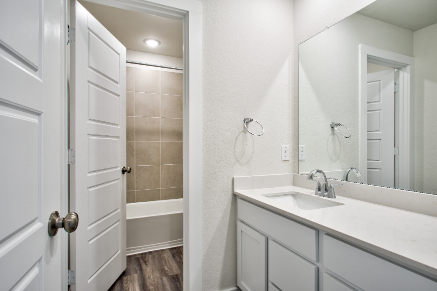 A bathroom with a sink and a mirror.