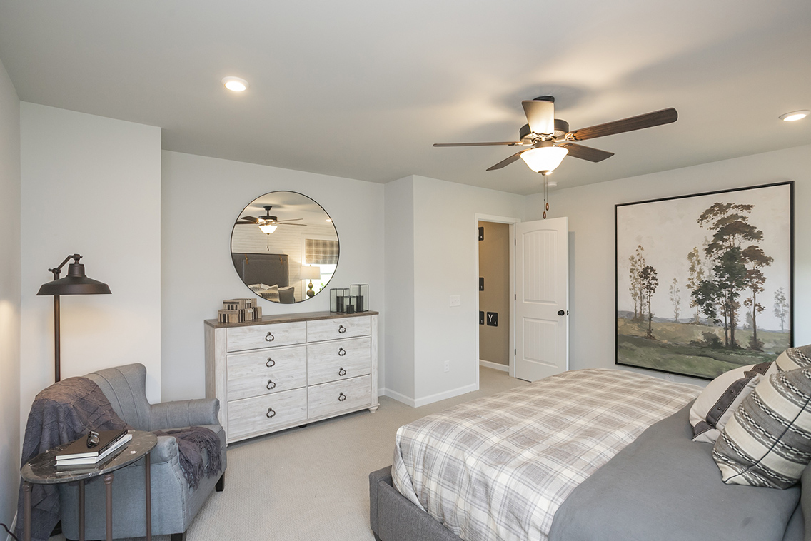 A bedroom with a large mirror.