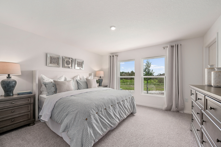 A bedroom with a large window.