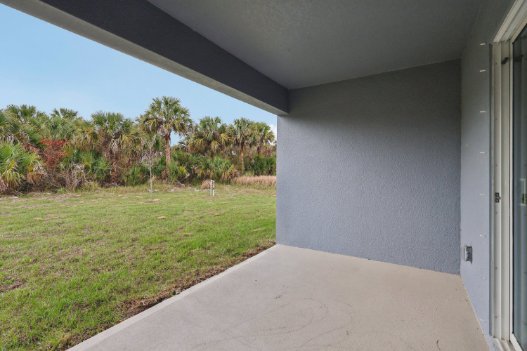 A concrete walkway with grass and trees.