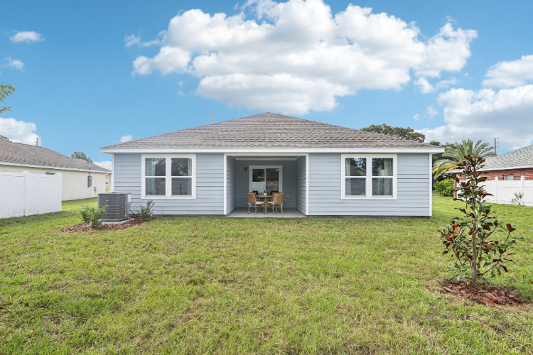 A house with a yard and a chair in the front.