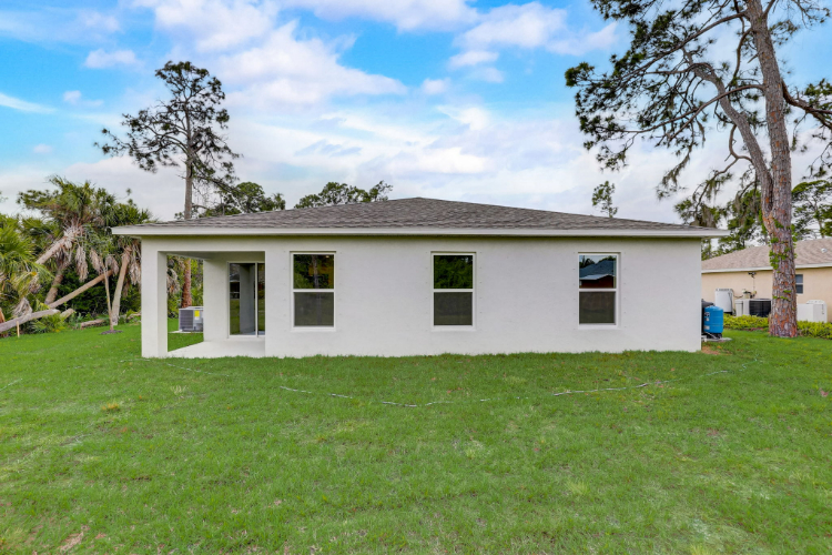 A white house with a grass yard.