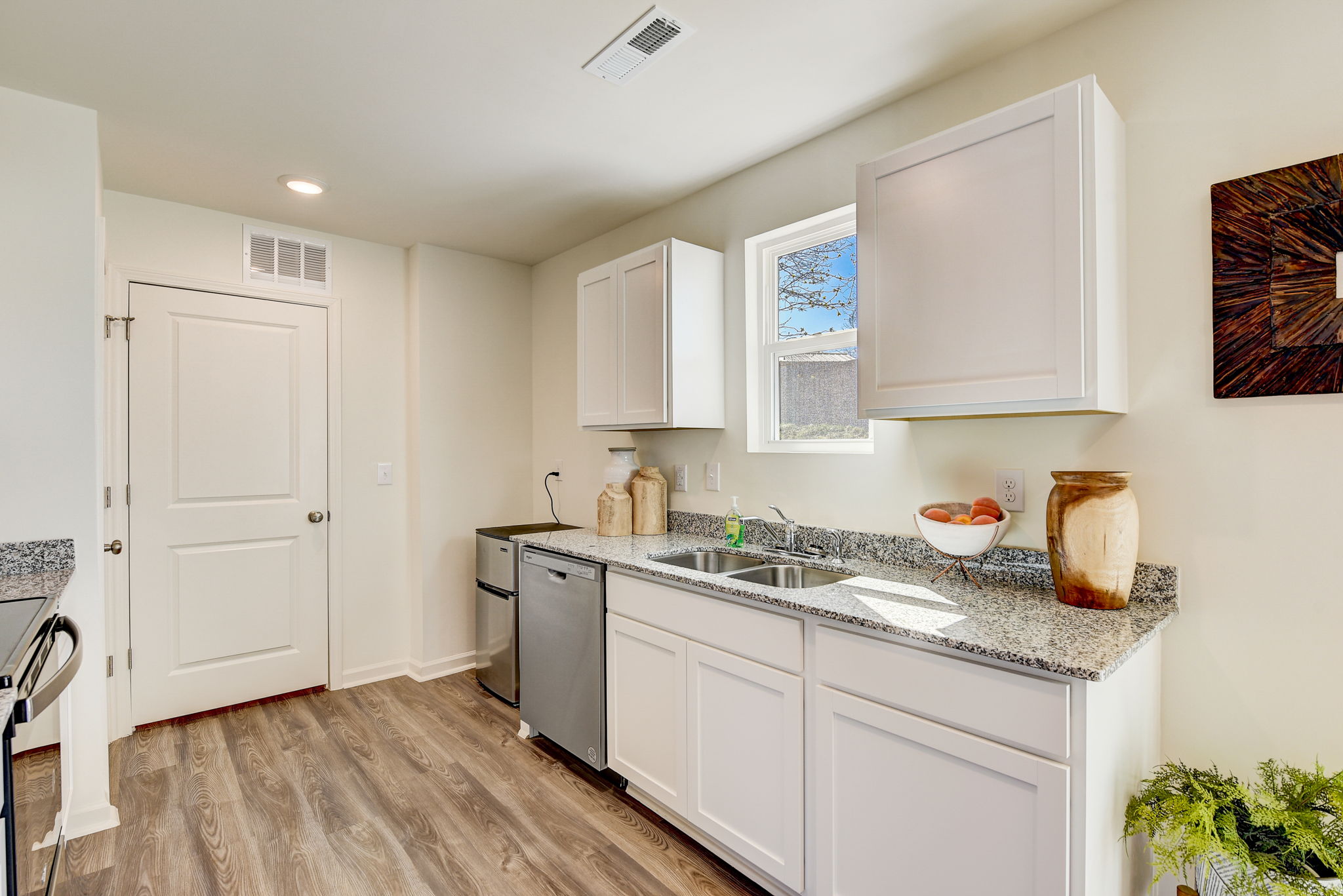 A kitchen with white cabinets.